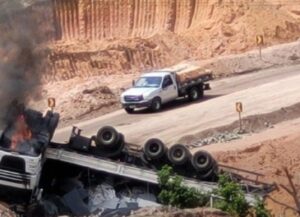 Carreta carregada de granito cai em ribanceira, capota e pega fogo em desvio na BR-101