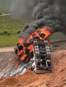 Carreta carregada de granito cai em ribanceira, capota e pega fogo em desvio na BR-101